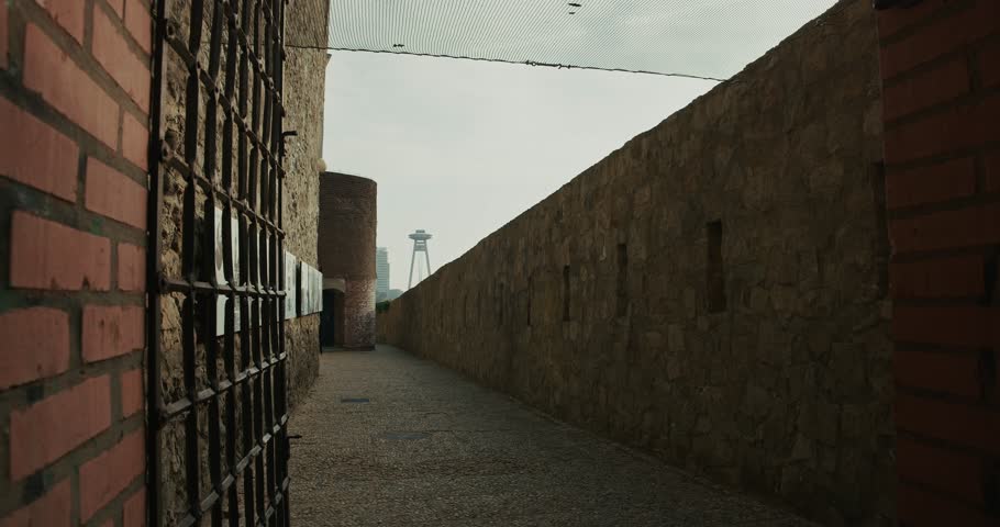 narrow stone passageway, where history whispers through every rugged wall and rusted grate