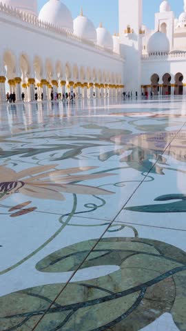 View of Sheikh Zayed Grand Mosque in Abu Dhabi made of snow-white marble with flowers made of precious. Shot handheld. Vertical video