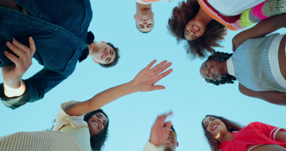 Happy people, hands together and huddle with applause for motivation below for unity, teamwork or mission. Low angle, group or circle with piling or stack in solidarity for community development