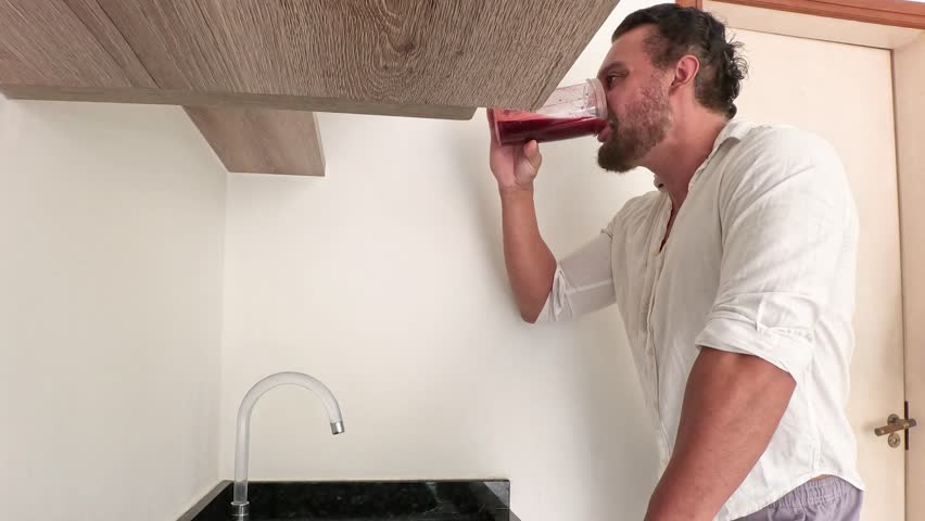 Man alone preparing healthy juice from beetroot, orange, spinach