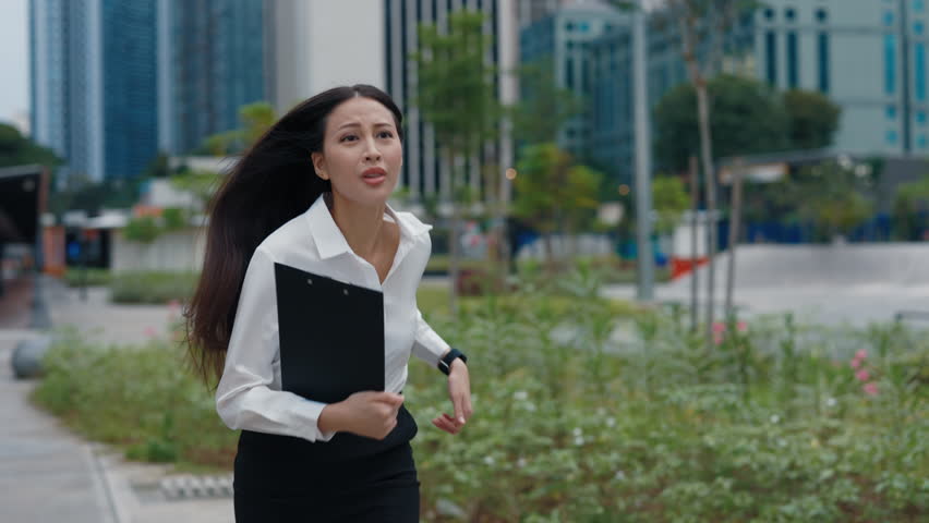 Young Asian Business Lady Running On The Street During Rush Hour. Charming Manager Girl Hurry Up For The Meeting, Looking At The Hand Clock. People Concept