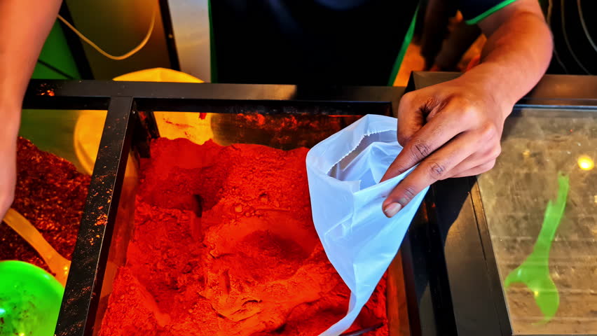 Spice stand at the Weligama local Fish Market. Close up on merchant packing up fresh paprika powder