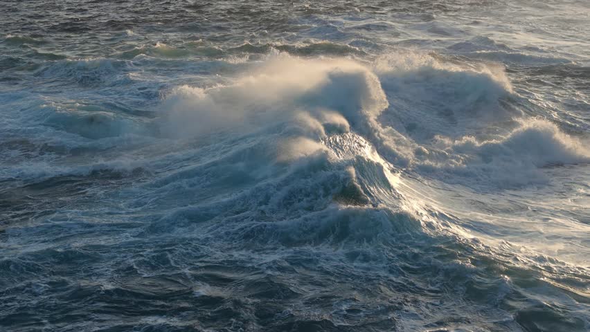 Huge power ocean wave crashing over sunset sky background. Slow motion of stormy ocean surf splashing on the coast of Madeira, Porto Moniz
