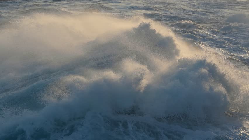 Huge power ocean wave crashing over sunset sky background. Slow motion of stormy ocean surf splashing on the coast of Madeira, Porto Moniz