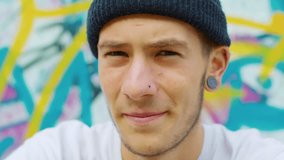 Close-up of a skateboarder with a graffiti background. - Powered by Shutterstock - Get 15% off with code: PIKWIZARD15