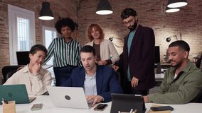 Diverse team collaborating on a project, using a laptop in a modern office environment. Slow motion emphasizes their teamwork and focused expressions - Powered by Shutterstock - Get 15% off with code: PIKWIZARD15