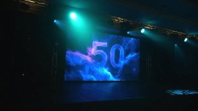 An empty concert stage with a large screen with the number 50, multicolored spotlights flashing with different lights. A festive backdrop for the fiftieth anniversary. - Powered by Shutterstock - Get 15% off with code: PIKWIZARD15