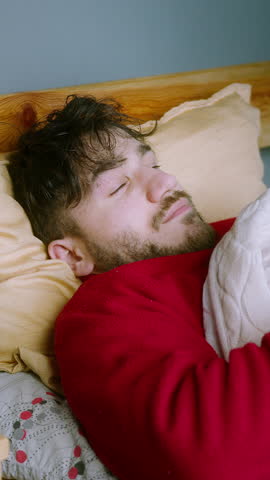 Man Yawning and Smiling in Bed – Relaxed and Happy on a Vacation Morning ,vertical video