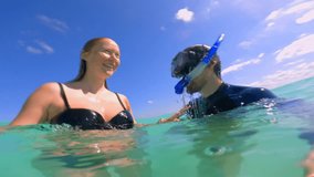 Underwater moment of a man wearing a diving mask, gently hugging and touching the belly of his pregnant wife. A serene and emotional scene of connection and love captured in clear ocean waters - Powered by Shutterstock - Get 15% off with code: PIKWIZARD15