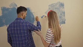 Young couple painting heart on wall in new home living room expressing love and creativity together indoors - Powered by Shutterstock - Get 15% off with code: PIKWIZARD15