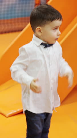 kids are having fun at birthday party in playground zone room with children entertainer.smiling happy boys and girls are dancing, jump and clap.joy emotions on preschoolers face.