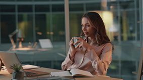 Entrepreneur relaxing evening office with coffee. Thoughtful professional rest reflecting with mug in hand. Peaceful successful executive dreaming at night workplace. Woman in contemplative mood. - Powered by Shutterstock - Get 15% off with code: PIKWIZARD15