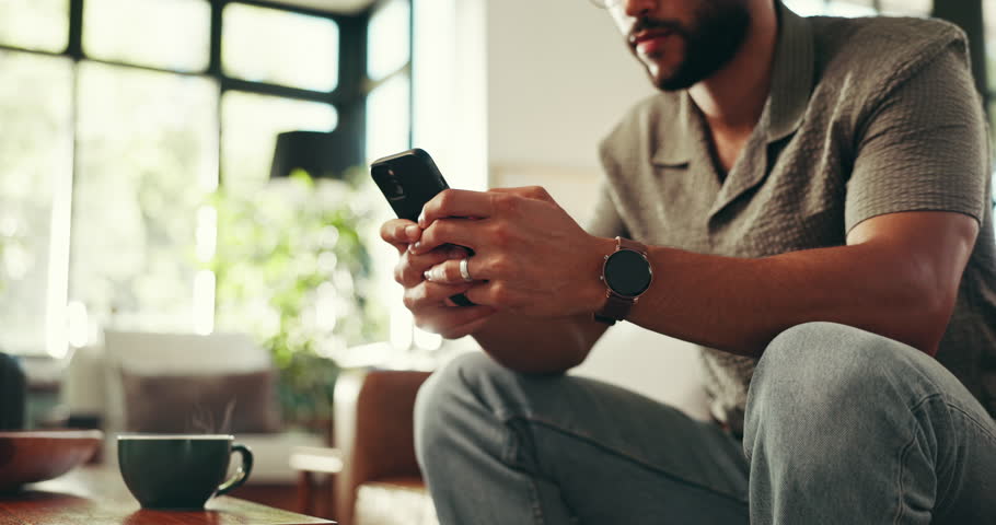 Relax, phone and typing with hands of man on sofa for social media, streaming or online update. Networking app, conversation and post with closeup of person in living room at home for chat and mobile