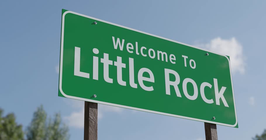 Driving By A Welcome To Little Rock, Arkansas Green Road Sign Against a Blue Sky and Clouds - United States Capital Series.