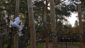 Children climbing rope course on wooden playground in autumn park. Concept of outdoor activity, adventure sports, and kids' physical development. High quality 4k footage - Powered by Shutterstock - Get 15% off with code: PIKWIZARD15