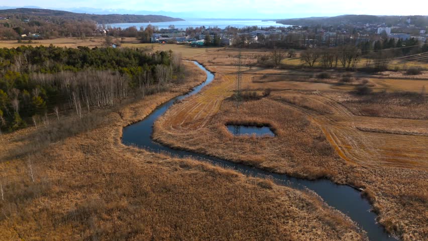 Aerial view of Upper Wurm River between Starnberg and Leutstetten, Bavaria. Clear water, wetlands, green meadows, and forests. Only outflow of Lake Starnberg, flowing through nature reserve in spring