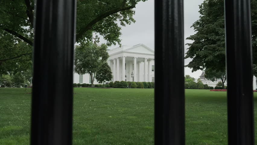 The White House in Washington DC seen through fence around the house	
