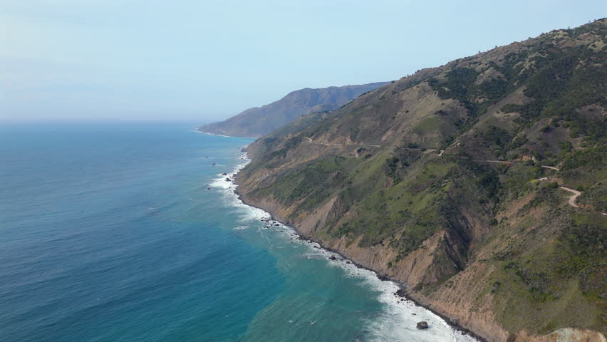 Immerse yourself in the breathtaking beauty of Big Sur by viewing this stunning aerial perspective of the magnificent coastline and the iconic Highway 1 located in the beautiful state of California