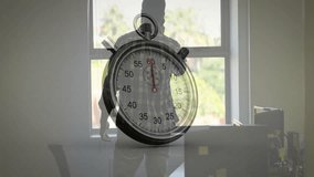 Standing by window, person using stopwatch animation overlay, focused on timing. Time management, precision, technology, digital, concentration, punctuality - Powered by Shutterstock - Get 15% off with code: PIKWIZARD15