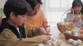 Asian young boy and father coloring Easter eggs on table in house. Happy family, adorable kid with daddy enjoy spend time playing and painting Easter egg on holiday festive in living room at home. - Powered by Shutterstock - Get 15% off with code: PIKWIZARD15