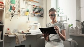 Fashion student taking notes and practicing sewing techniques in home workshop. Concept of skill development, craftsmanship, and online learning. Woman learns how to use sewing machine - Powered by Shutterstock - Get 15% off with code: PIKWIZARD15