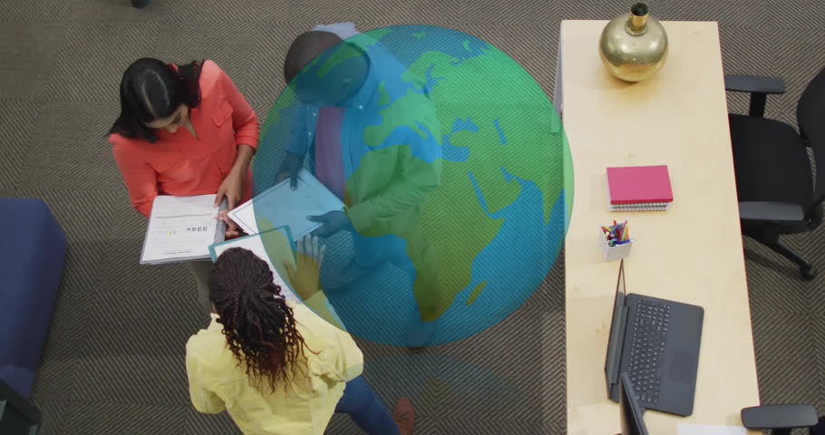Diverse team collaborating at office with digital globe animation overlay. Business, teamwork, technology, innovation, collaboration, corporate