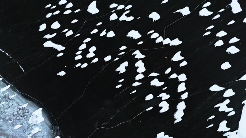 Tromsø fjords with scattered ice and dark waters, serene winter landscape, aerial view