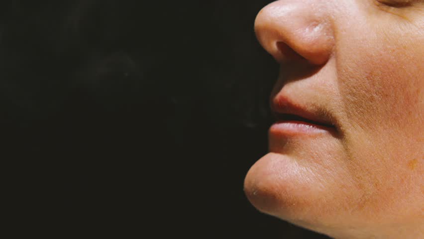Close-up profile shot of a woman's face inhaling thick white vapor with lips ajar, with detailed skin texture. Reverse shot of vape smoking