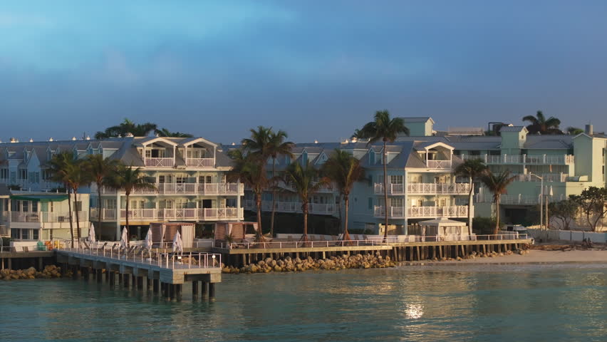 A breathtaking aerial photograph captures the beauty of Sunset Key in Key West, Florida, displaying colorful buildings and tranquil waters during a picturesque sunset hour