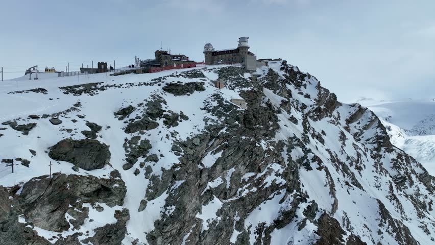 Aerial flyover with a full rotation around winter Gornergrat with views of Matterhorn, Gornergrat train station and hotel, Gorner glacier, Monte Rosa