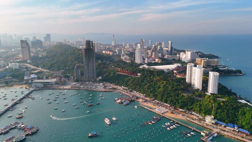 Scenic harbor with boats and vibrant Pattaya city along coast