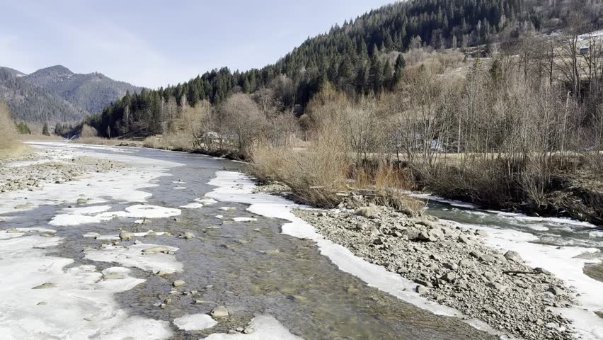 Partially Frozen River with Melting Ice in Early Spring	