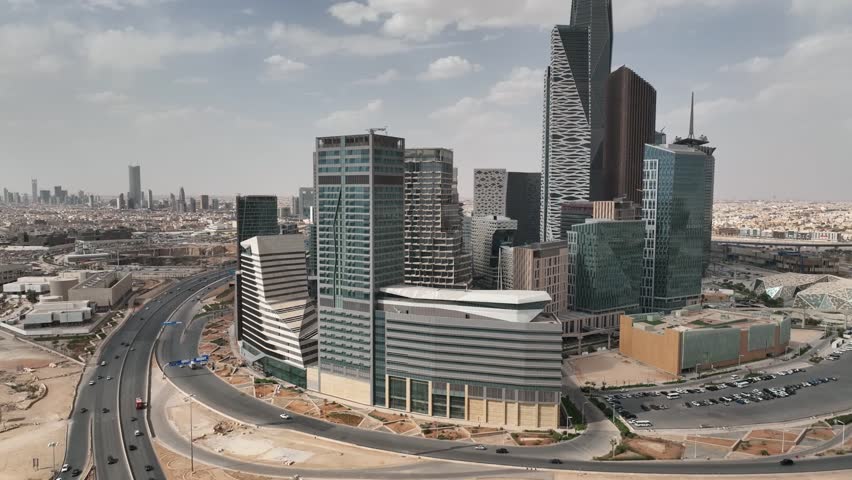 A striking aerial view of Riyadh highlighting the modern towers of the King Abdullah Financial District and its surrounding roads, showcasing the city’s rapid growth and contemporary urban landscape. 