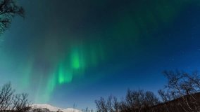 Northern lights dance over snowy Finnish landscape in a mesmerizing time-lapse view - Powered by Shutterstock - Get 15% off with code: PIKWIZARD15