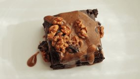 Chocolate brownies garnished with caramel and nuts. Sweet food. High quality 4k footage - Powered by Shutterstock - Get 15% off with code: PIKWIZARD15