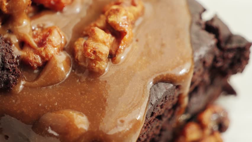 Chocolate cake with nuts and salted caramel. Delicious brownies on a plate. High quality 4k footage