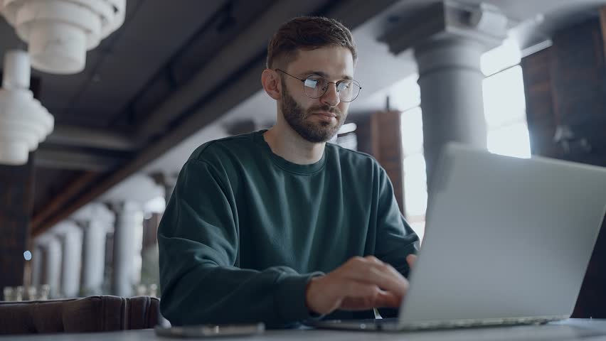 Bearded Man With Eyeglasses Working With Laptop Remotely From Cafe, Freelance And Part-Time Job - Powered by Shutterstock - Get 15% off with code: PIKWIZARD15