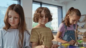 Creative children painting at art lesson in elementary school closeup. Group talented pupils focused on creativity crafting colorful pictures. Cute schoolchildren using paints in artclass together. - Powered by Shutterstock - Get 15% off with code: PIKWIZARD15