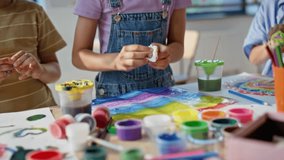 Children creating colorful crafts at art workshop closeup. Little schoolchildren collaborating in vibrant artclass with creative tools. Primary school pupils working together enjoy artistic activity. - Powered by Shutterstock - Get 15% off with code: PIKWIZARD15