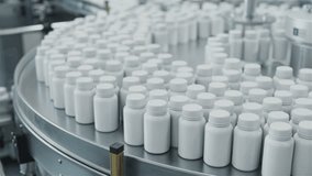 White Plastic Bottles Filled with Pills on Rotary Conveyor at Pharmaceutical Production Plant. Medication Manufacturing Process at Pharmaceutical Drug Factory  - Powered by Shutterstock - Get 15% off with code: PIKWIZARD15