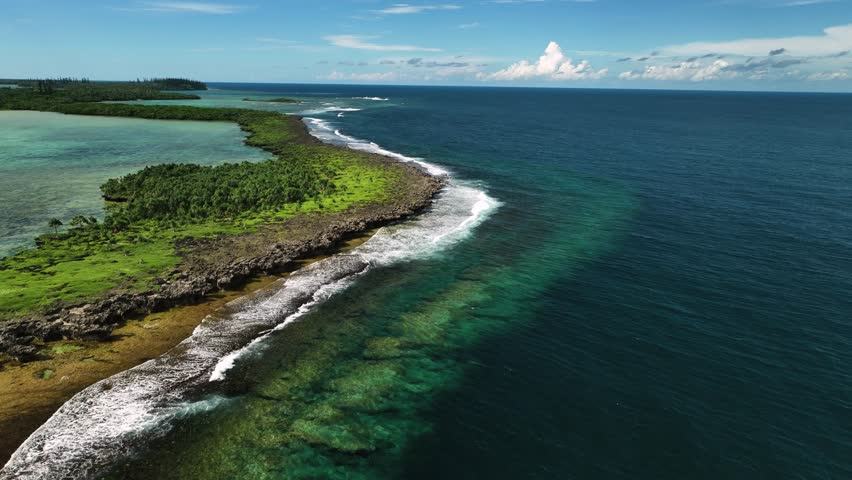 Aerial view of pristine tropical reef and serene waves along the coastline, Goro, South Province, New Caledonia.