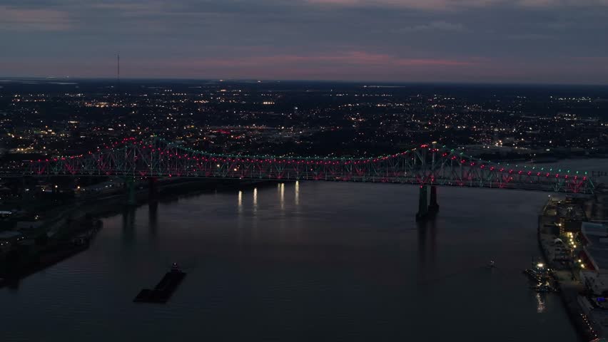 Aerial view of Crescent City Connection bridge over the Mississippi River at sunset with illuminated skyline, French Quarter, New Orleans, Louisiana, United States.