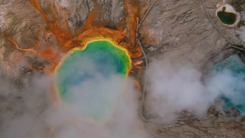 Aerial view of the grand prismatic spring with colorful thermal features and mist, Yellowstone National Park, Wyoming, United States.