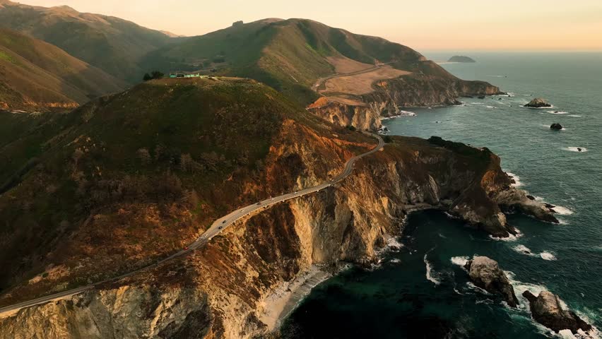 Aerial view of bixby creek bridge at sunset surrounded by fog over the rocky coast, Big Sur, California, United States.