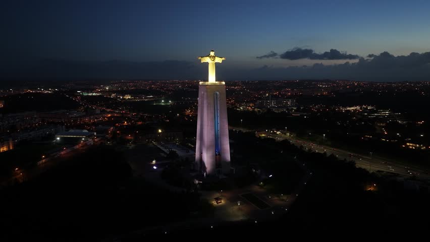 Night View Of King Christ At Almada In District Of Lisbon Portugal. Illuminated Christ The King. Tourism Landmark. King Christ At Almada In Portugal. 25Th April Bridge Scenery. Postcard Landscape.
