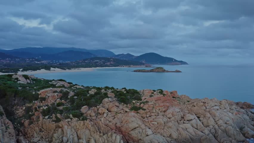 Aerial view of Capo Spartivento and Spiaggia di Cala Cipolla with a cloudy sky at dusk, Domus de Maria, Sardinia, Italy.