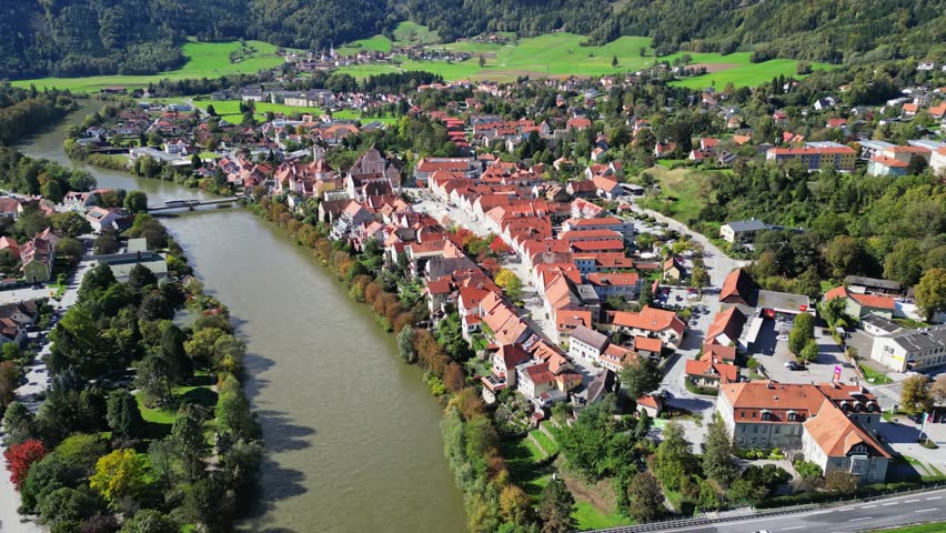 Aerial view of historic old town with river Mur and picturesque rooftops surrounded by greenery, Frohnleiten, Styria, Austria.