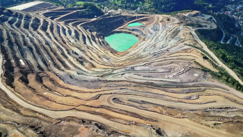 Aerial view of an open pit iron mine and stone pit with industrial development and beautiful patterns, Erzberg, Styria, Austria.