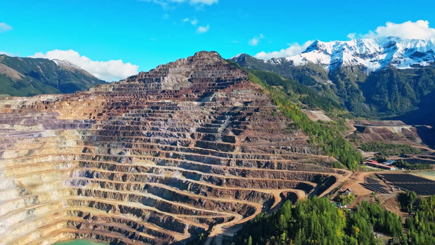 Aerial view of open pit iron mine surrounded by mountainous landscape, Erzberg, Styria, Austria.