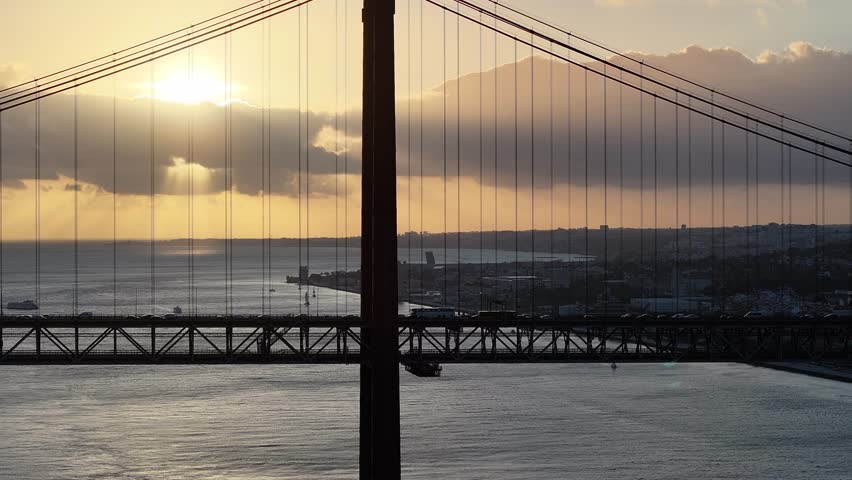 Sunset Sky Over 25 Of April Bridge At Lisbon In Lisbon District Portugal. Sunset Downtown. Freeway Road Landscape. 25 Of April Bridge At Lisbon In Portugal. Cable Stayed Bridge Scenery.